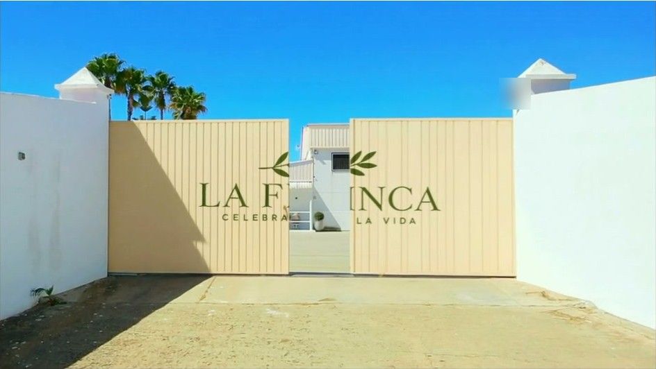 El portón recreado en color crema con el logotipo de La Finca